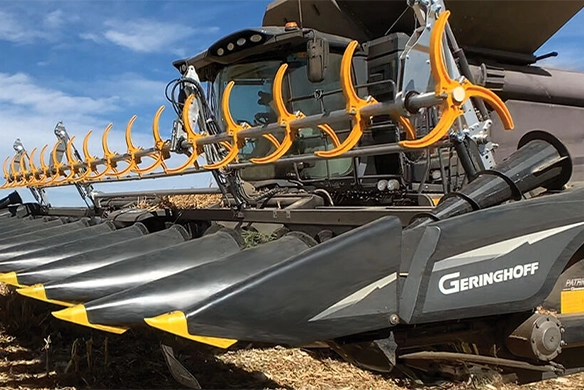 Geringhoff Patriot corn head mounted on a combine harvester, featuring durable poly snouts and crop gathering system in action during harvest.