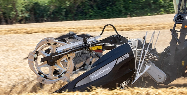 MacDon FD230 Flex Draper header attached to a Fendt IDEAL combine, efficiently cutting and feeding crops in a harvested wheat field, highlighting its flexible design and precision performance.