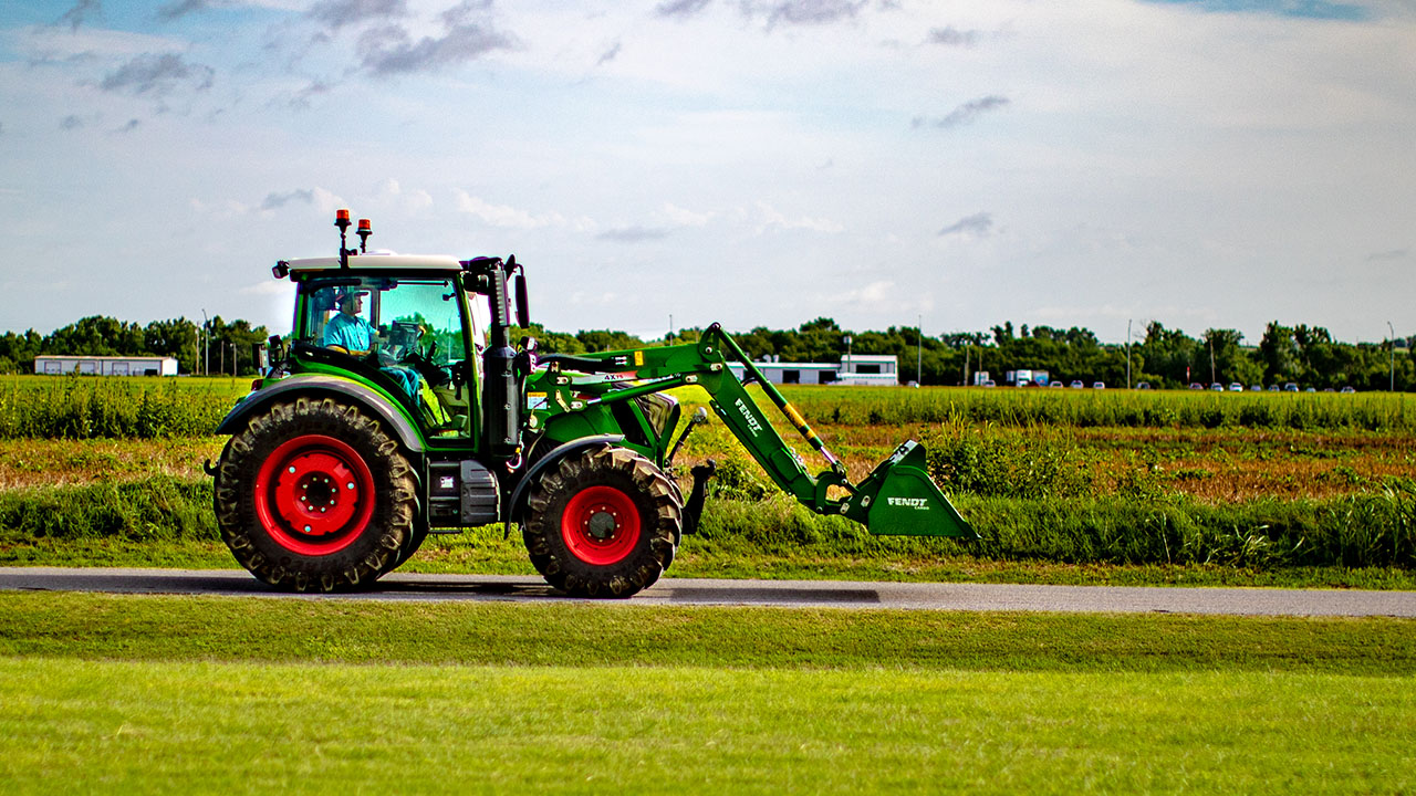 Fendt 300 Vario tractor driving past field, showcasing compact power and AGCO performance versatility.