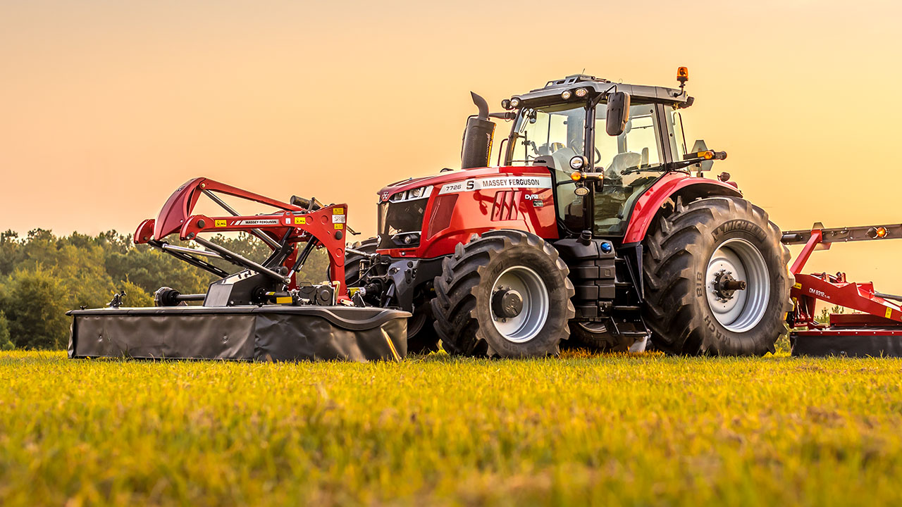 Massey Ferguson tractor with MF DM Series Triple Mower cutting grass at sunset, built for high-efficiency, wide-area mowing.