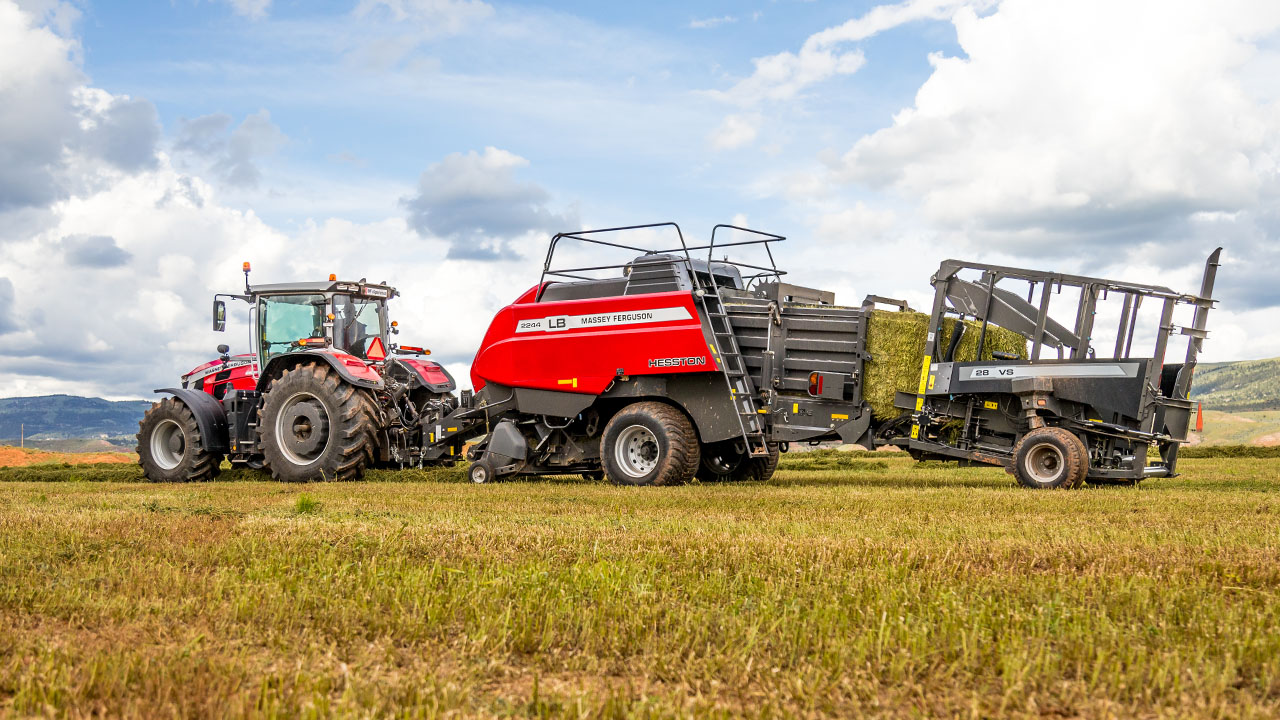 Hesston by Massey Ferguson LB2200 Series baler in-field with Massey Ferguson tractor and hay stacker, producing square bales.