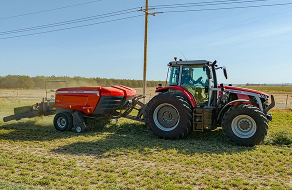 Massey Ferguson tractor towing Hesston 1436 Series double baler through a hay field, illustrating high-capacity square baling for large-scale forage operations.