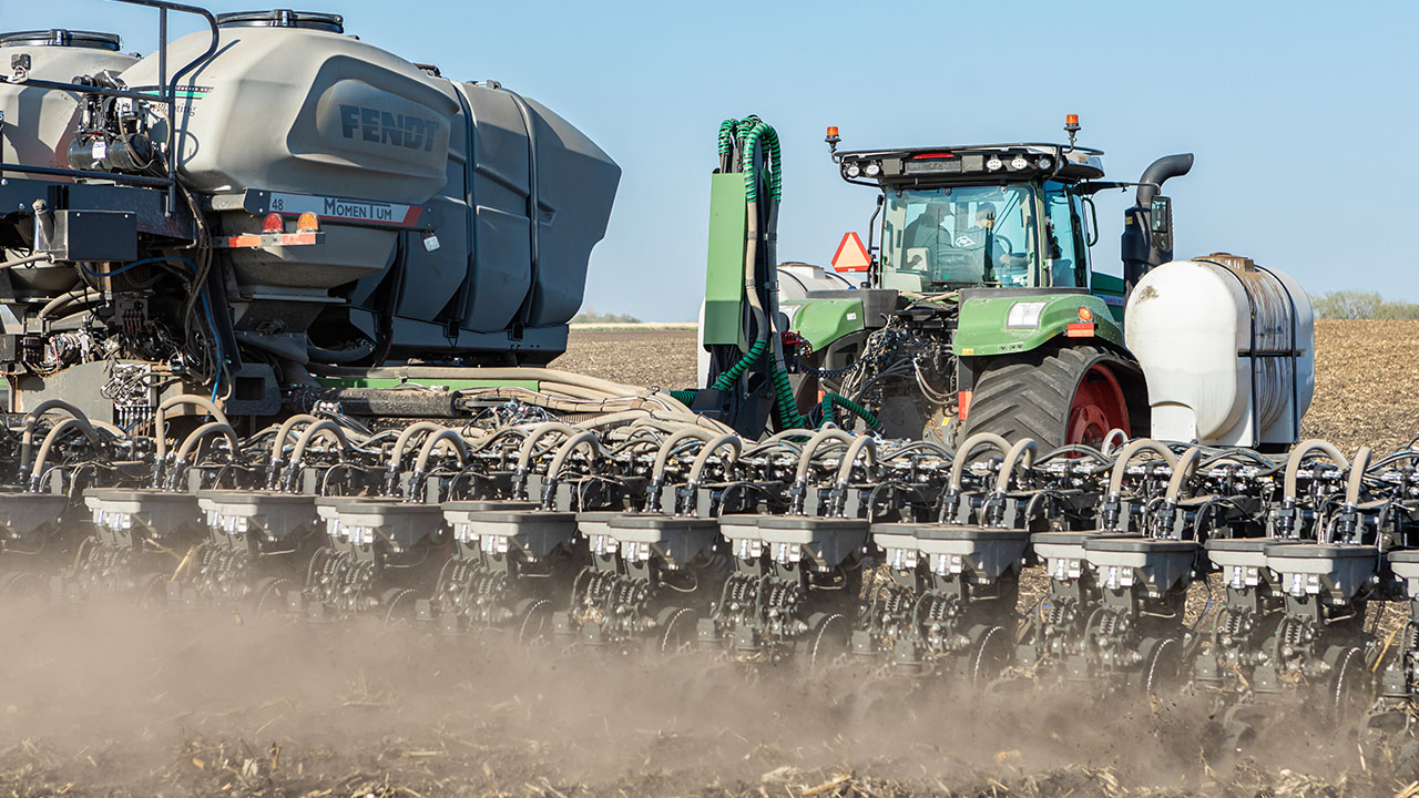 Fendt Momentum planter with Fendt tractor and seed tender operating in open field during spring planting season.