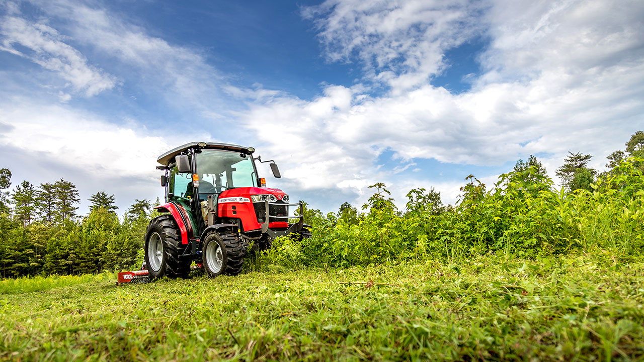 Massey Ferguson 2800M Series tractor mowing field with rotary cutter, ideal for property maintenance and brush clearing tasks.