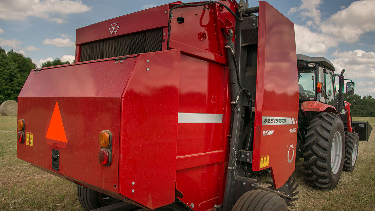 Rear view of Hesston by Massey Ferguson 1700 Series round baler in field, built for reliable hay production and compact performance.