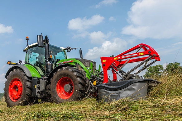Operator using Massey Ferguson 367 Front Mower with a Fendt tractor in agricultural setting.
