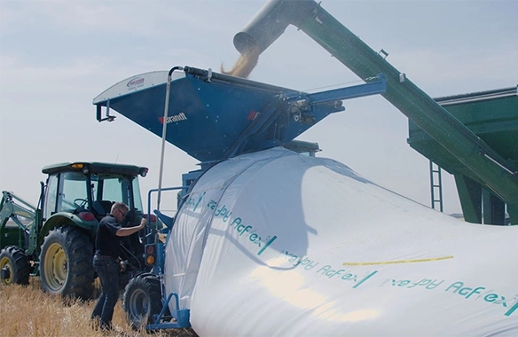 Brandt GrainBagger paired with a tractor, providing high-efficiency, on-site grain storage during harvest.