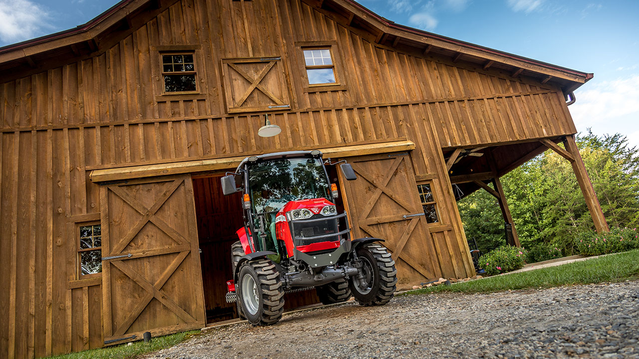 Massey Ferguson 2860M compact utility tractor leaving barn, built for durability, comfort, and versatile farm work.