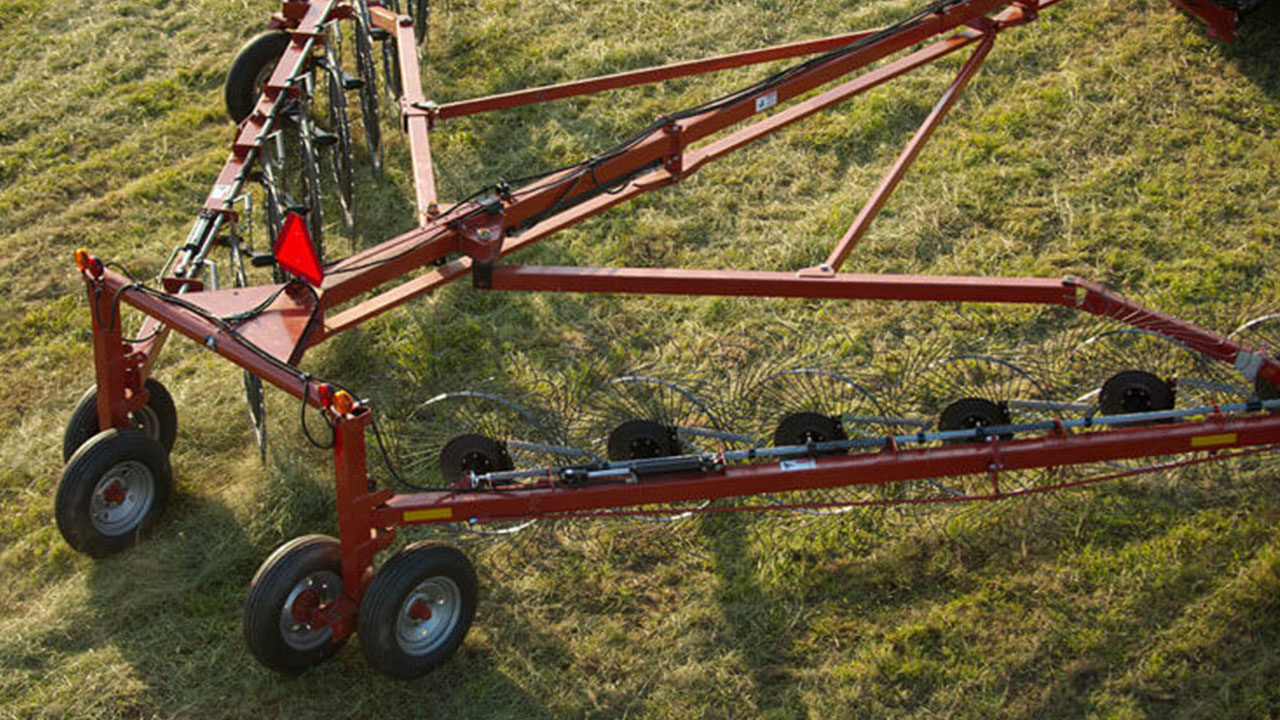 Close-up of MF 3900 Series Wheel Rake tines and frame gathering hay, built for durability and clean windrow formation.