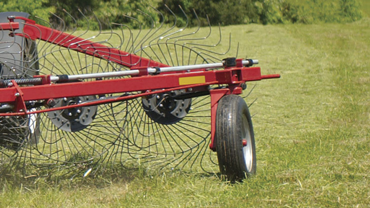 Close-up of MF 3900 Series Wheel Rake tines and frame gathering hay, built for durability and clean windrow formation.