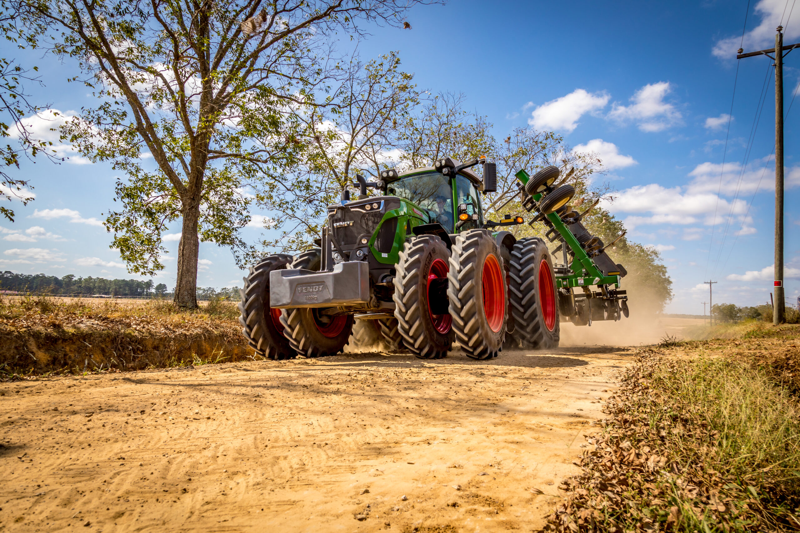 Fendt 900 Vario tractor hauling implement on dirt road in rural Georgia, showcasing durability, traction, and high-performance farming.