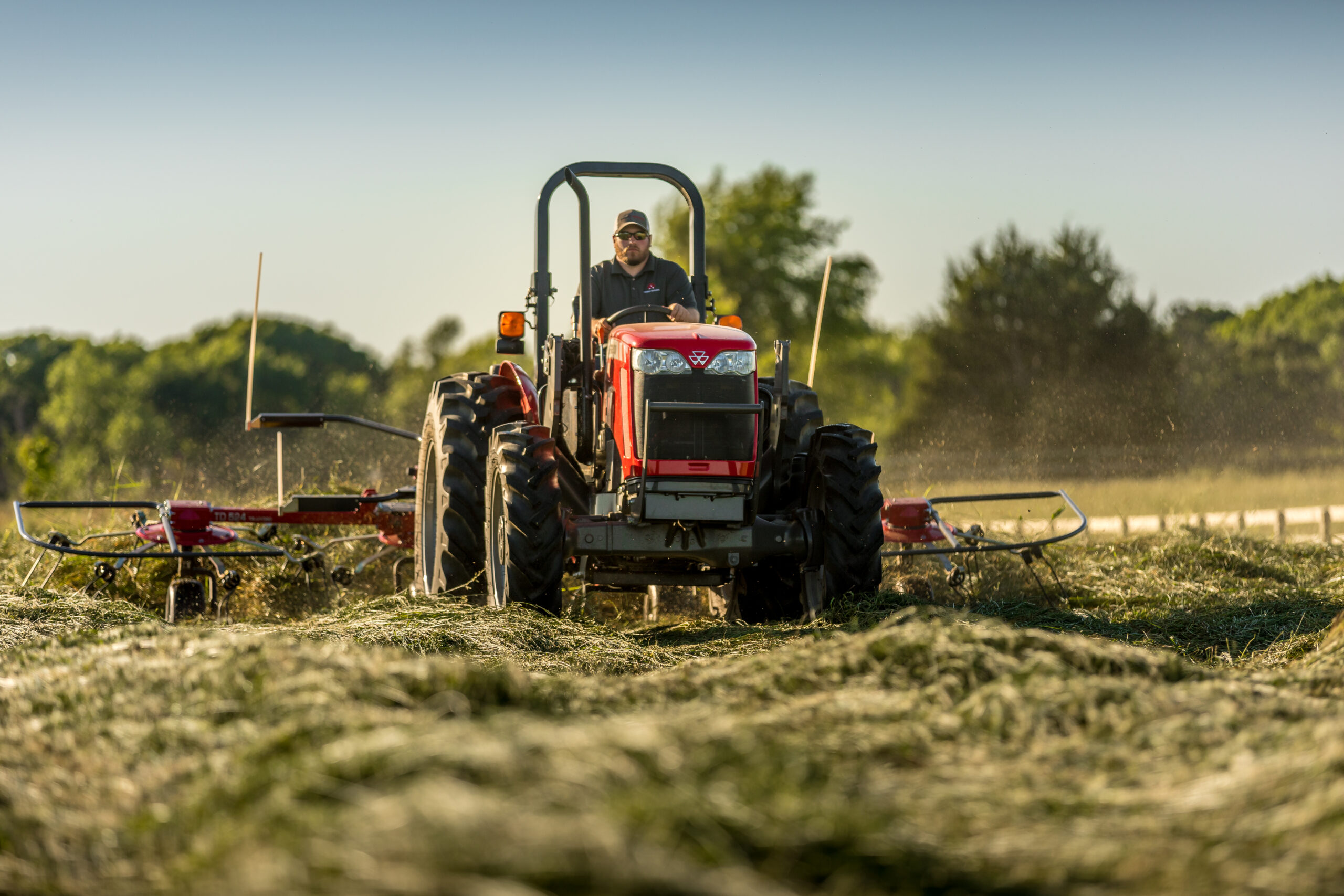 Operator mowing field with a Massey Ferguson 2600H utility tractor, built for dependable performance in pasture and land management.