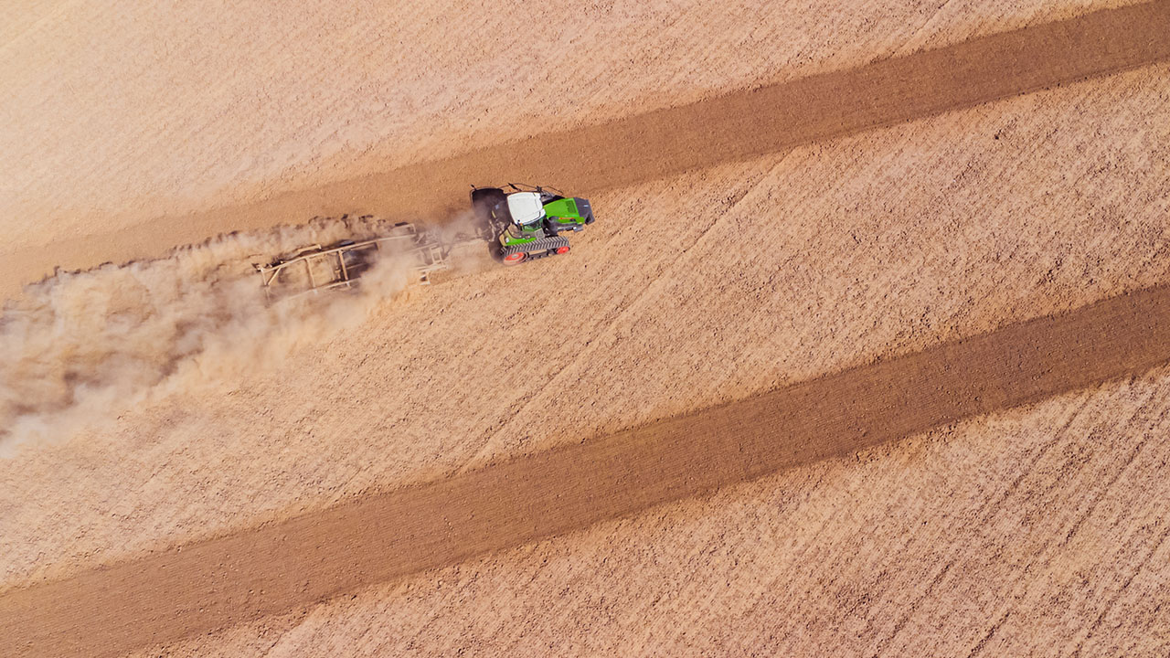 Fendt 1100 Vario MT tractor with tracks working a dusty field, showcasing high-power tillage and precision farming performance.