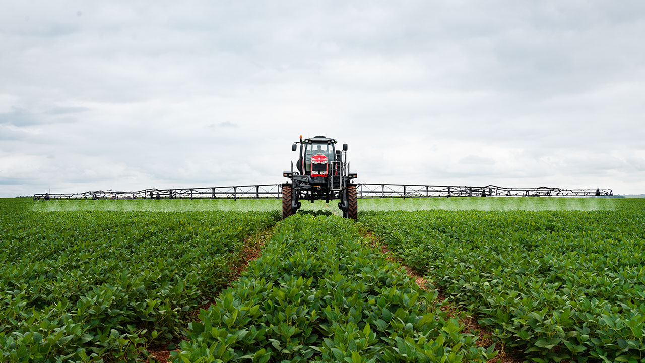 Massey Ferguson 500R sprayer applying crop treatment across a lush soybean field with wide boom coverage and precision.