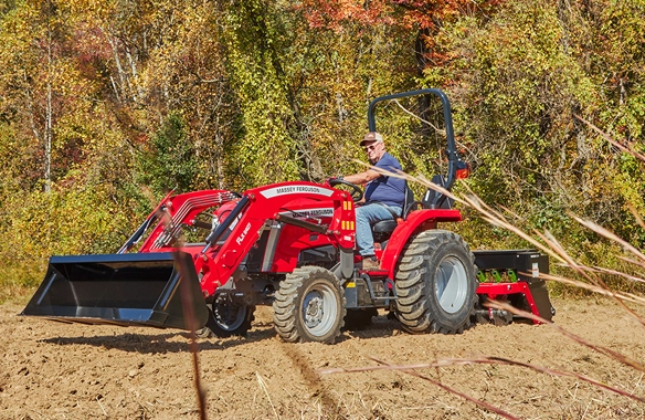 Side profile of the Massey Ferguson 1E Series compact tractor in operation, emphasizing its compact design and maneuverability.