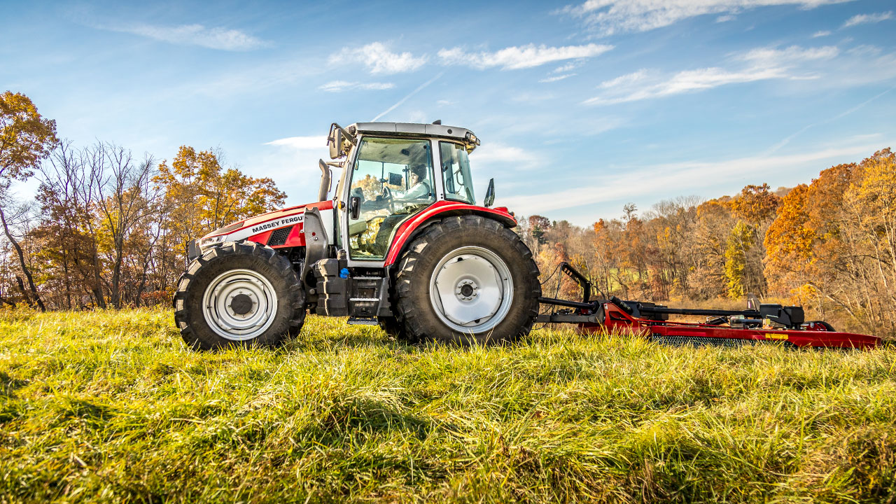 Thumbnail for Massey Ferguson 5S Series tractor operating a rear mower on a grassy hill during autumn, ideal for hay and pasture management.