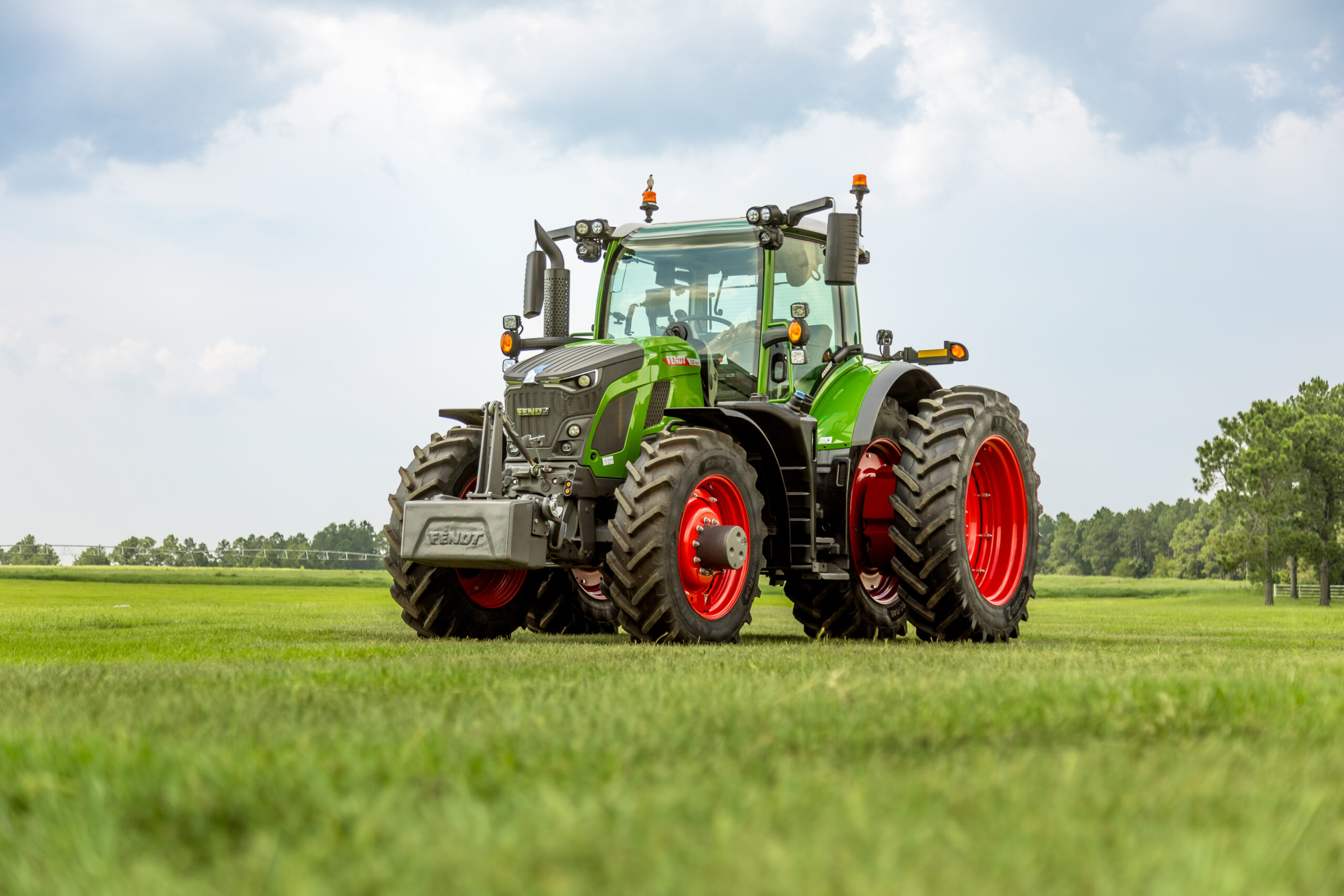 Fendt 600 Vario tractor with dual rear tires parked on open grassy field under partly cloudy sky.