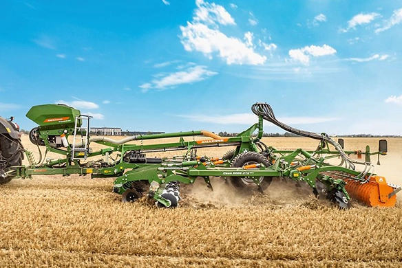 Side view of Amazone Ceus 6000-2TX combined cultivator and disc harrow in action with Fendt tractor, tilling wheat stubble under bright skies.
