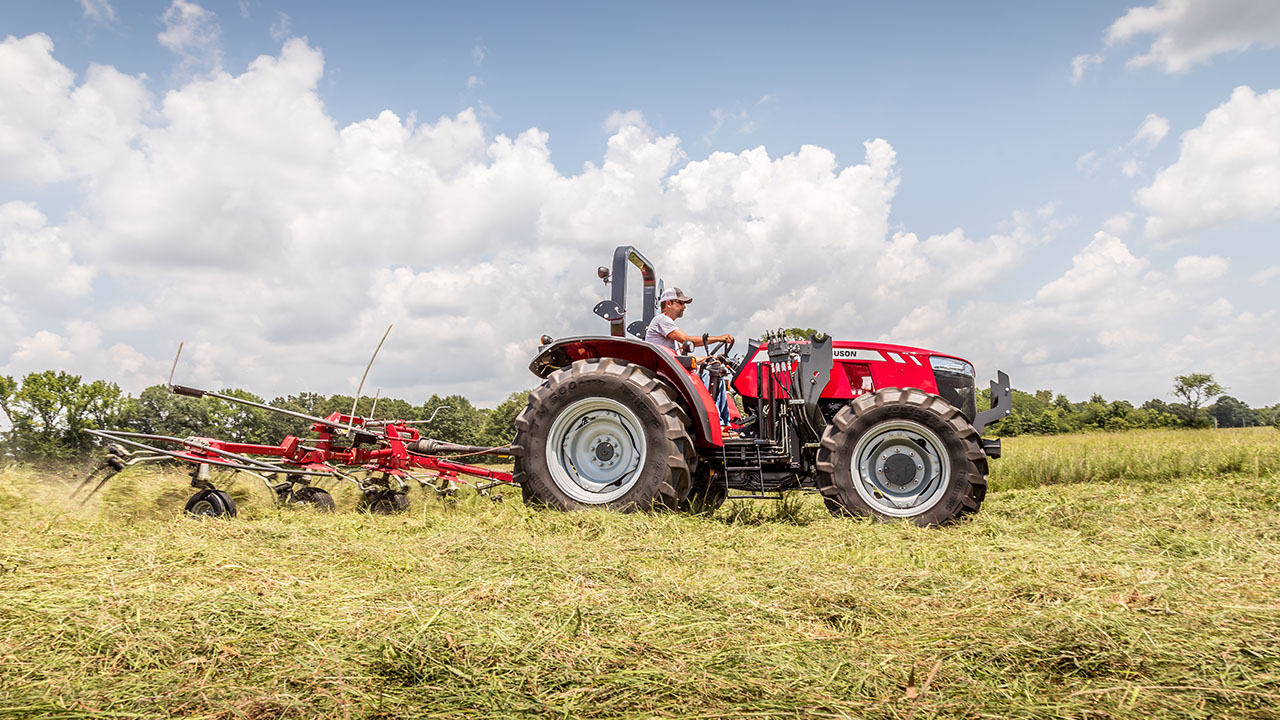 Massey Ferguson tractor using MF TD Series Tedder in field, spreading hay evenly to speed drying and improve forage quality.